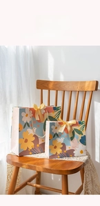 Detail of floral gift bags with silk bow and rope handles on a lace tablecloth