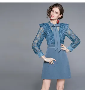 Détail d'une robe en dentelle bleu clair avec poitrine à volants et col à nœud