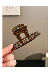 Detail shot of large amber marble hair claw clip with blue and brown acetate texture