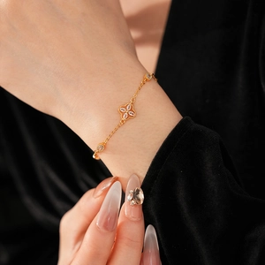 Detail of adjustable gold flower bracelet with sparkling zircons on model wrist