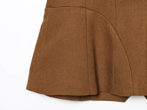 Close-up of caramel brown linen-blend fabric showing detailed diagonal twill texture and stitching
