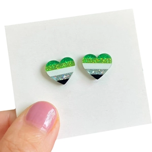 Détail de boucles d'oreilles cœur drapeau aromantique à rayures pailletées vert et noir