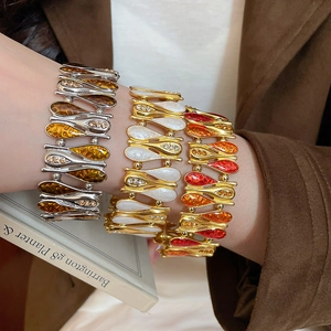 Close-up of three retro stretch bracelets with enamel water-drop patterns and rhinestones