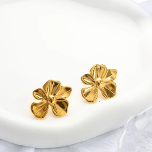 Detail of 18K gold plated flower earrings showing metallic texture and floral shape