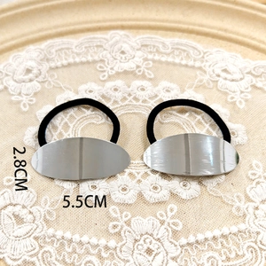 Detail view of a minimalist silver alloy hair tie set with 5.5cm oval metal plate dimensions