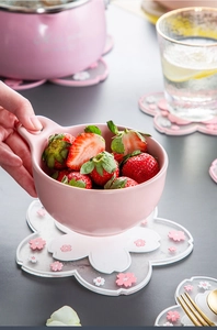 Detailed view of a pink cherry blossom PVC coaster with a ceramic fruit bowl in a set