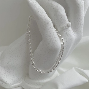 Detail of minimalist 925 sterling silver double-layer bracelet with small oval beads