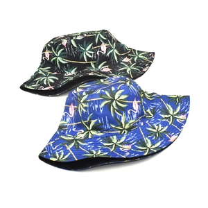 Reversible bucket hat with tropical palm trees and pink flamingo print in black and blue