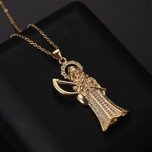Vue macro détaillée du pendentif Santa Muerte doré avec incrustations de zircon brillant