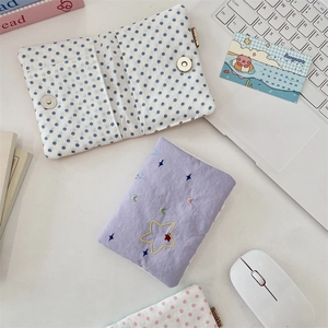 Detail of fabric passport holder featuring star embroidery and blue polka dot patterns