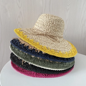 Détail de chapeaux de soleil en raphia colorés montrant la texture tissée et les bords ondulés