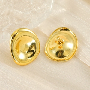 Detail shot of irregular oval gold earrings with a concave 18K gold-plated mirror finish