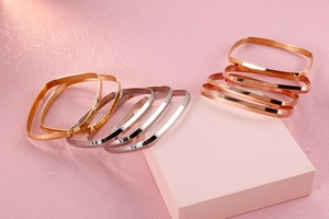 Detailed view of square titanium steel bangles in gold, silver, and rose gold finishes