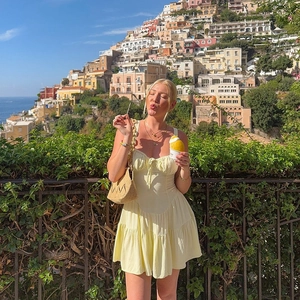 Détail de la robe d'été jaune clair avec taille ajustée et ourlet à volants pour vacances