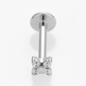 Macro detail of a silver stainless steel cross labret stud set with clear zircons