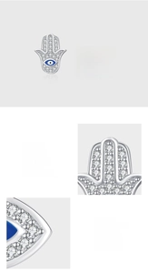 Détail macro de boucles d'oreilles Main de Fatma et Mauvais Œil en argent 925 et zircons