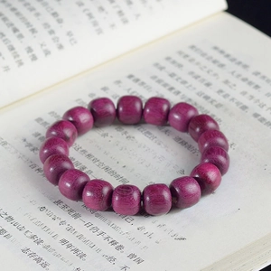 Detailed view of violet wood beads bracelet with natural grain on an open book