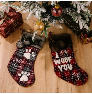 Detail of plaid pet Christmas stockings with paw prints and I Woof You embroidery