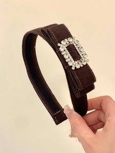 Détail d'un serre-tête en velours marron café avec boucle rectangulaire en strass