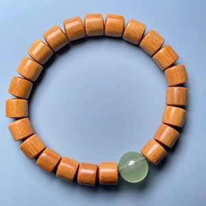 Detailed view of sandalwood bamboo-joint beads with a green translucent bead