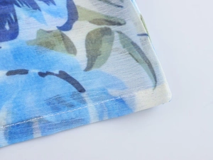 Macro di tessuto in chiffon a fiori blu con trama a rete e dettagli di cucitura fine