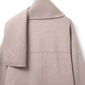 Detail of the light camel wool coat back showing the collar fold and seam craftsmanship