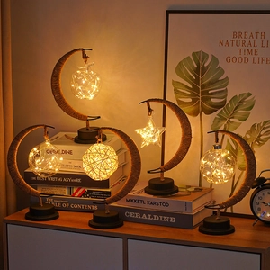 Close-up of moon-shaped LED night light with hemp rope and glowing glass ornaments