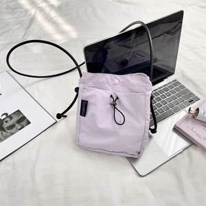 Dettaglio borsa a tracolla in nylon viola chiaro con chiusura a coulisse e logo