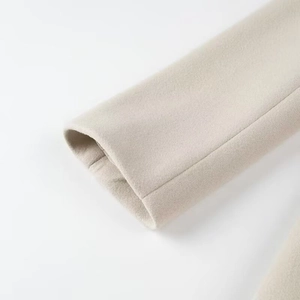 Détails des poignets en laine beige avoine montrant la texture et la couture précise