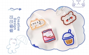 Detailed view of four acrylic cartoon clips featuring cat, bear, and snack designs