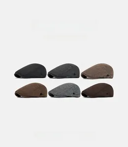 Dettaglio delle fibbie metalliche regolabili sui berretti vintage in tweed spigato