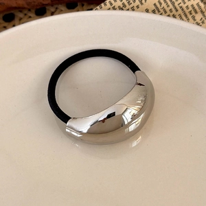 Close-up of a minimalist ponytail holder with a polished silver crescent metal accent