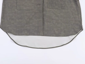 Detail of grey-green striped shirt featuring curved hemline and symmetrical utility pockets