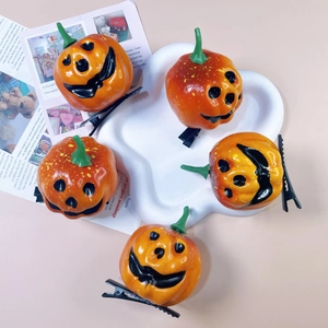Set of 5 orange foam pumpkin hair clips with smiling faces on a white ceramic plate