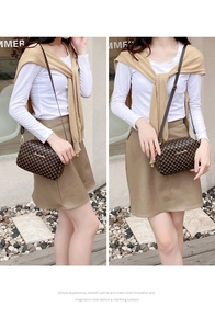 Detail of crossbody bag with dark brown geometric pattern and leather shoulder strap