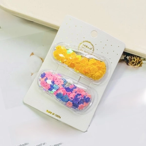 Detail of glitter flower sequins inside oval BB hair clips on handmade card display