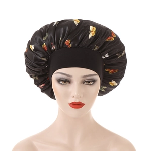Detail of black satin bonnet with colorful butterfly print and elastic wide band
