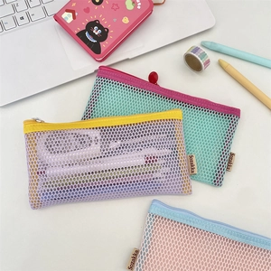 Close-up of pastel mesh pencil cases in purple and mint green on a desk workspace