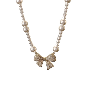 Elegant pearl bow necklace with cubic zirconia pendant in a French minimalist style