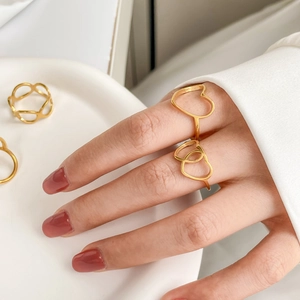 Detailed close-up of hollow heart-shaped gold rings with elegant line patterns
