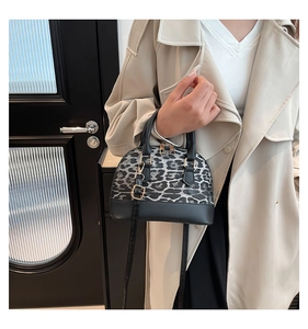 Chic shell bag featuring leopard print panels and black leather details on a trench coat model