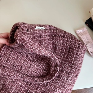 Dettaglio della trama della borsa in tweed rosa antico con etichetta interna