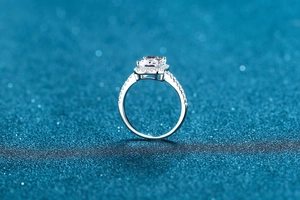 Macro view of emerald cut moissanite ring with halo setting and pave band on silver