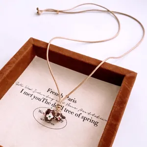 Vintage calabash pendant necklace with brown glaze and floral pattern on display