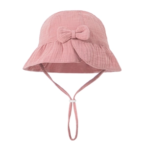 Detail of pink cotton muslin baby sun hat featuring a soft fabric bow and adjustable chin strap