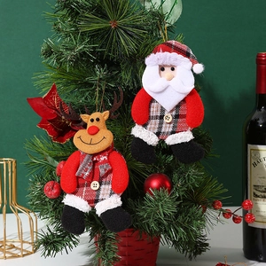 Close-up of Santa and reindeer plush ornaments hanging on a festive Christmas tree