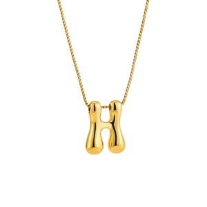 Macro detail of 18K gold letter H bubble pendant on a stainless steel box chain