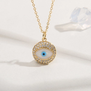 Gold Evil Eye pendant necklace with blue crystals and sparkling zircons on a white background