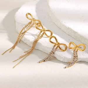 Detail of 18K gold plated bow earrings with sparkling zircon and delicate chain tassels