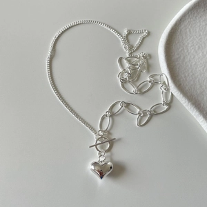 Close-up of 925 silver heart necklace featuring asymmetric chain and toggle clasp design